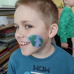chłopiec uśmiecha się na policzku ma namalowaną Ziemię.jpg