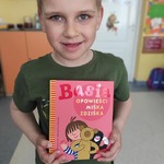 chłopiec trzyma w rękach ulubioną książkę.jpg