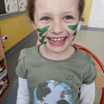 dziewczynka uśmiechnięta z zielonymi zygzakami na buzi.jpg