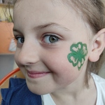 uśmiechnieta dziewczynka ma na buzi namalowaną zieloną koniczynkę.jpg