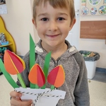 Chłopiec prezentuje swoje papierowe kwiatki.jpg